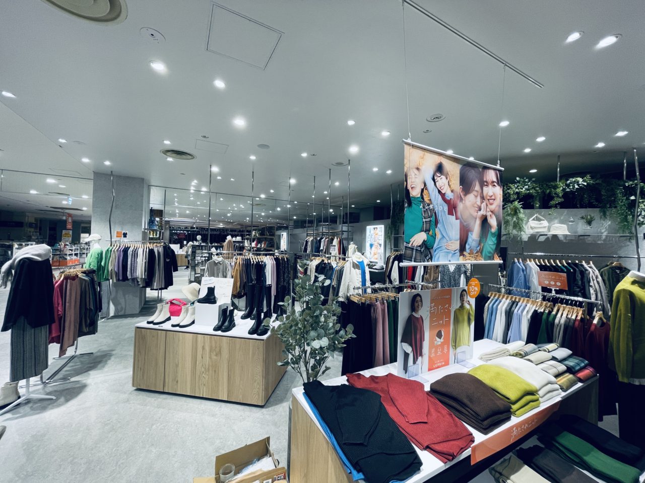 木目の平台とハンガーラックで衣服や靴を陳列したLadies’ apparel ICHIKAWAの売場